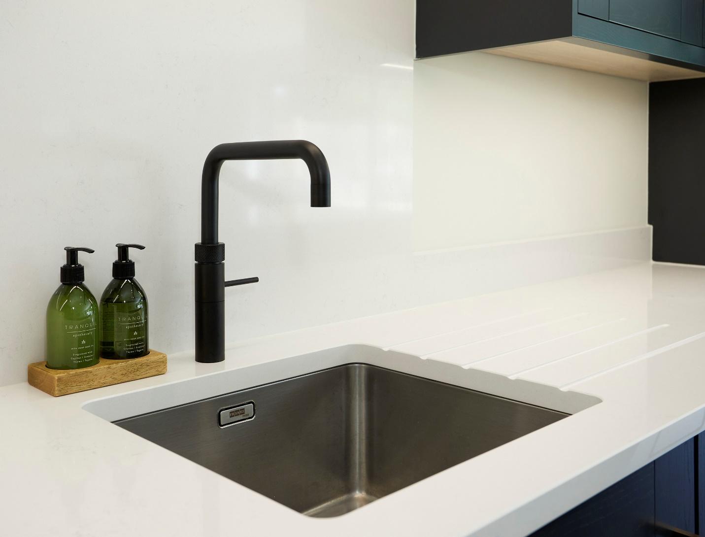 A sink and faucet in a kitchen

Description automatically generated