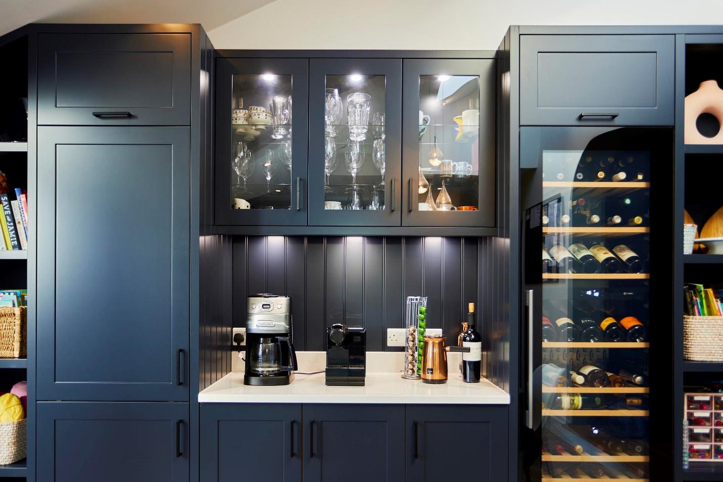 A kitchen with a wine fridge and a coffee maker

Description automatically generated