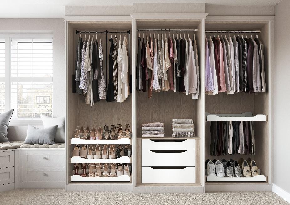 A large closet with clothes on a swinger

Description automatically generated