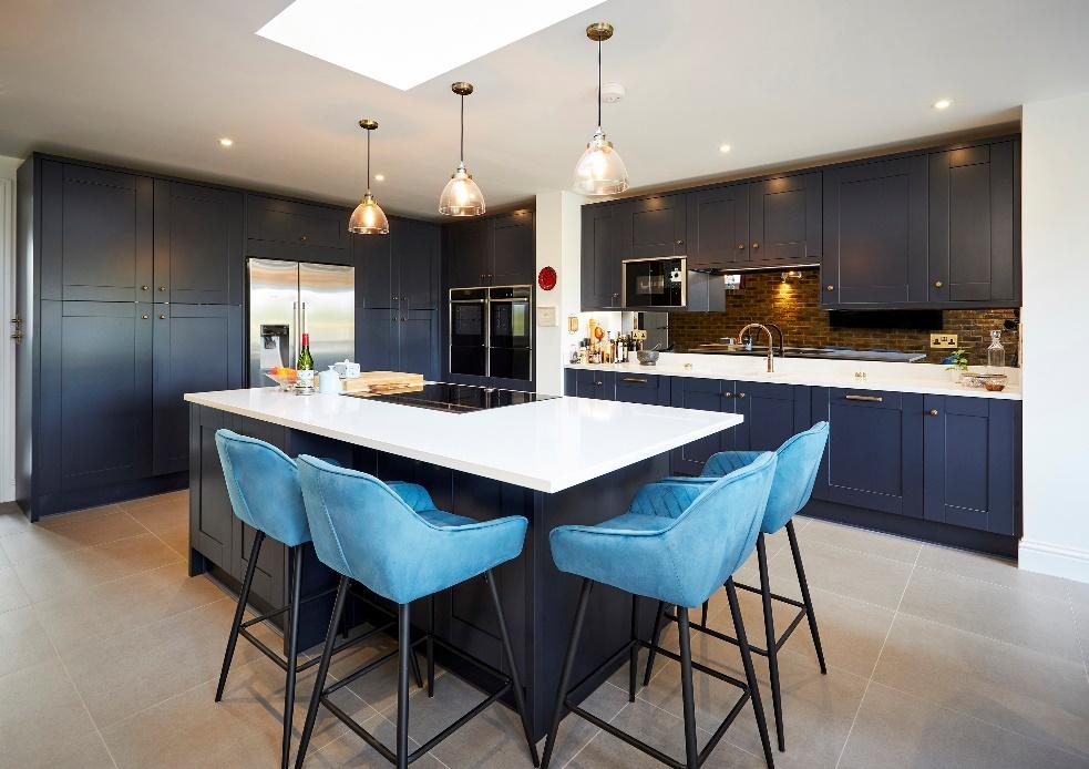 A kitchen with a large island and blue chairs

Description automatically generated