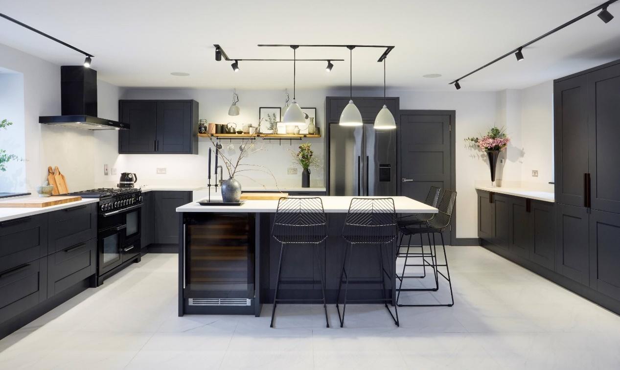 A kitchen with a white island and black chairs

Description automatically generated