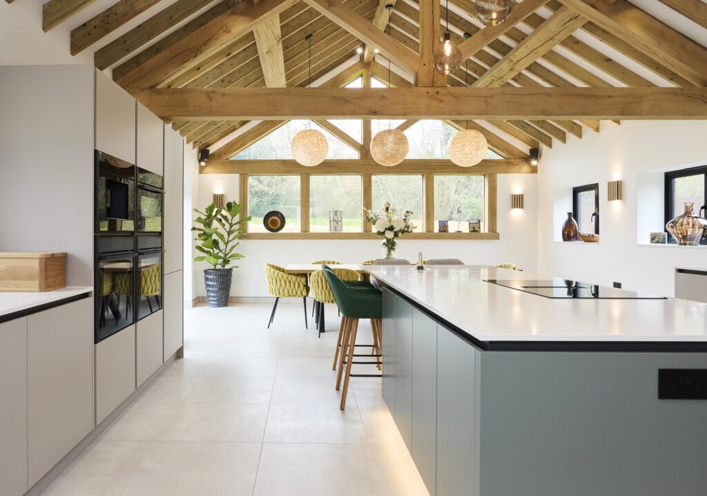 Spacious modern kitchen with island, vaulted ceiling, and bright seating - Ashford Kitchens & Interiors